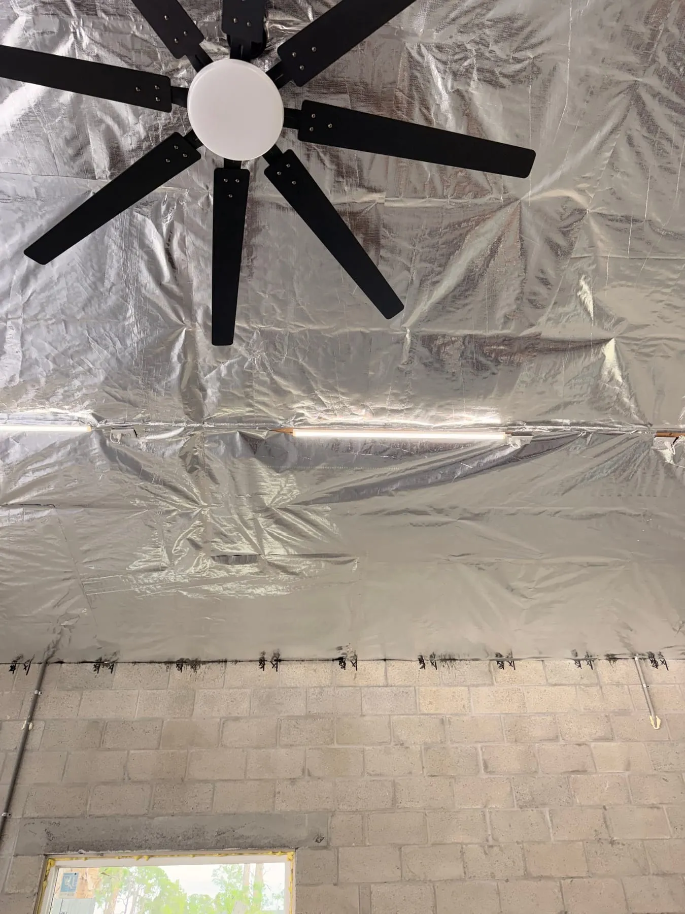 Reflective radiant barrier covering a garage ceiling