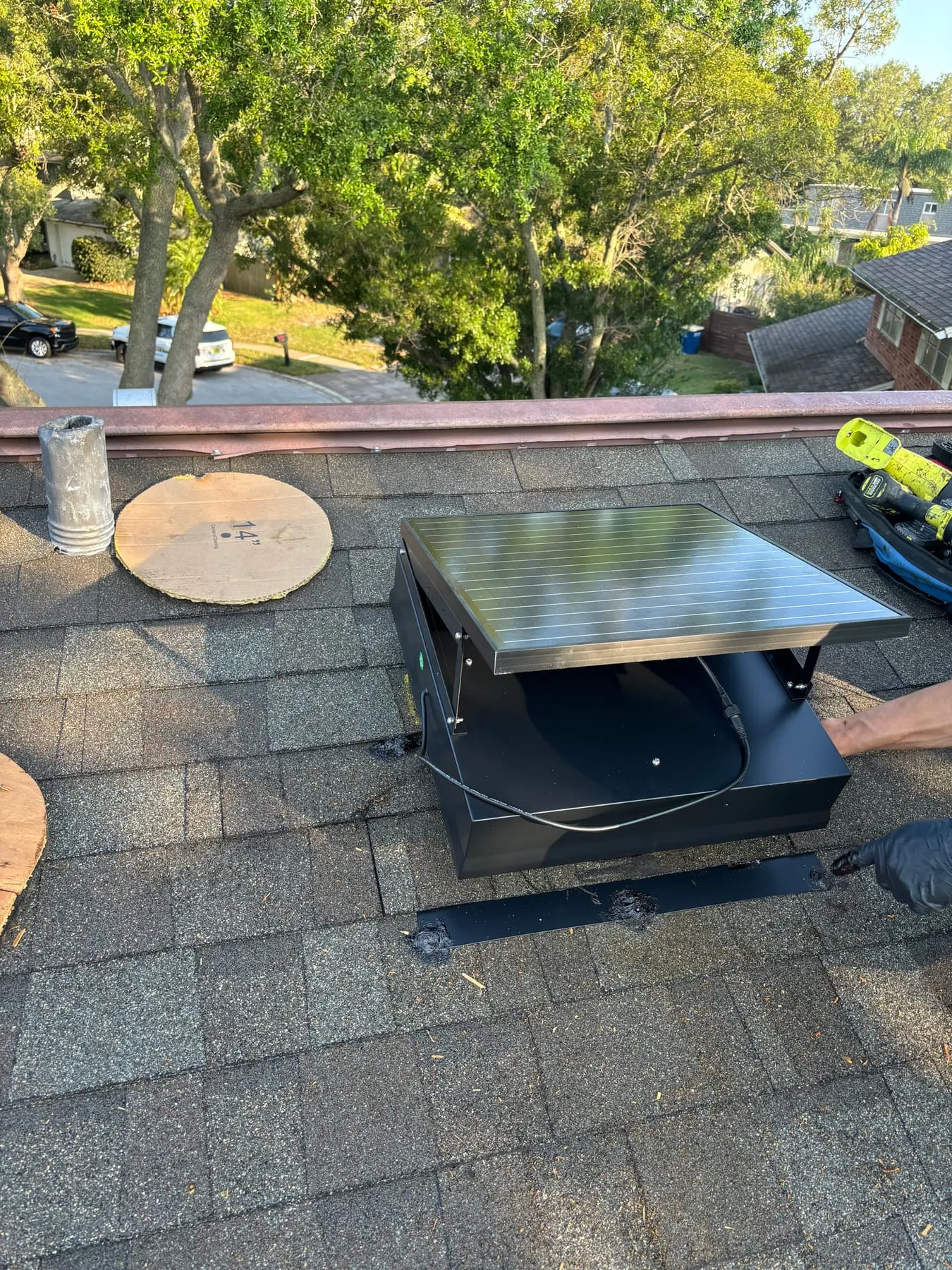 Newly installed solar attic fan on a roof