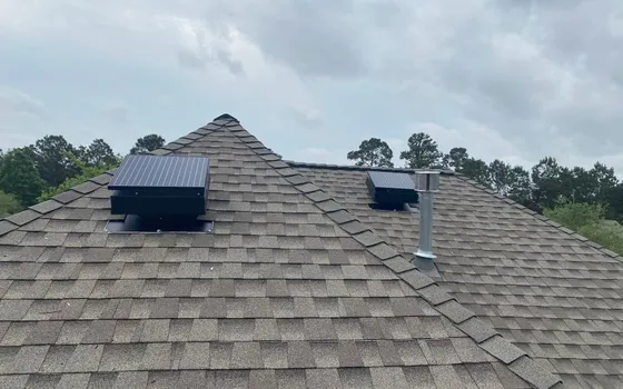 Two solar attic fans installed on a shingle roof
